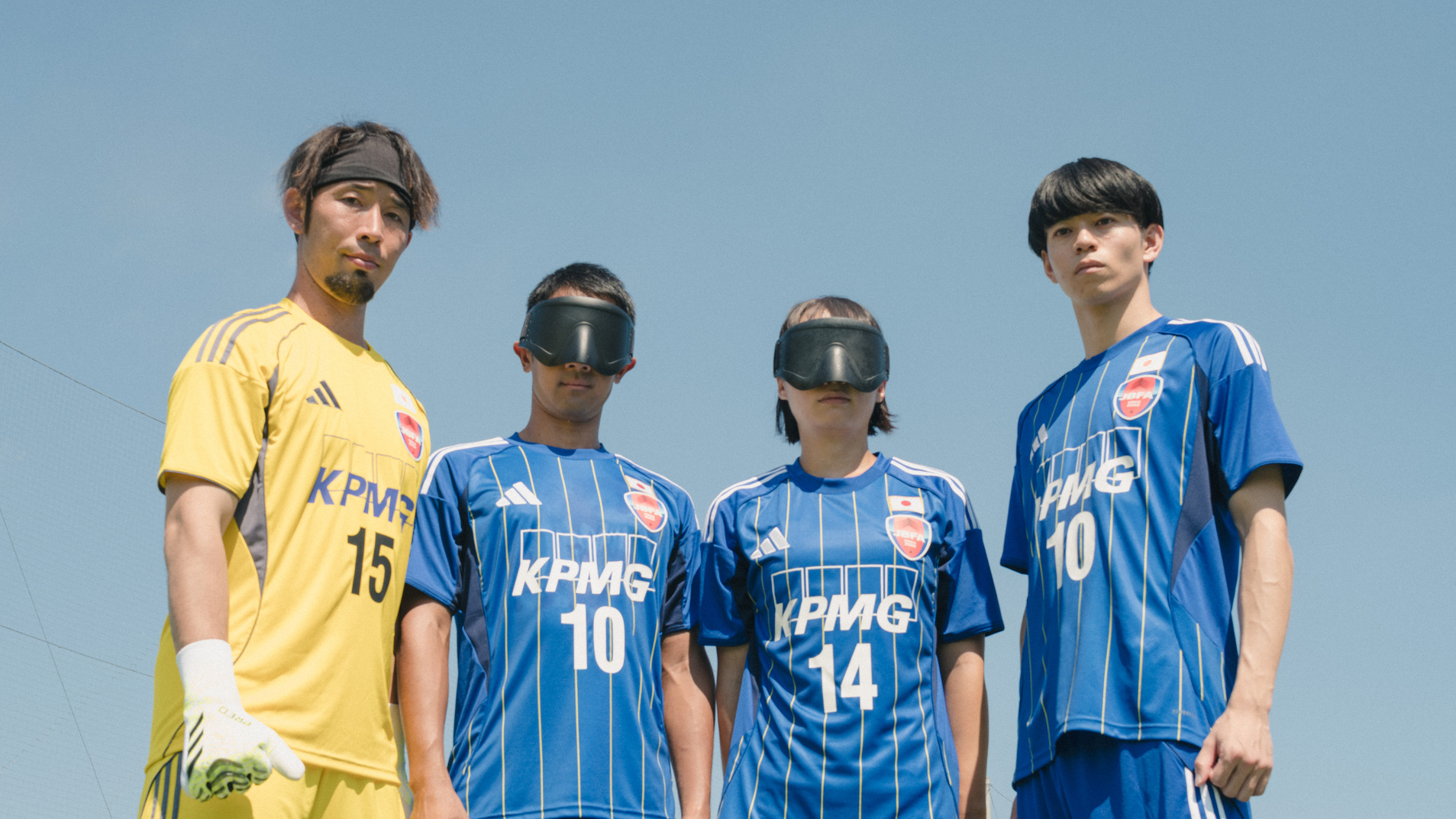 ブラインドサッカー日本代表選手たち　新ユニフォーム『ひかり』を着用しピッチに立つ　黄色のゴールキーパーと青のフィールドプレーヤー3名