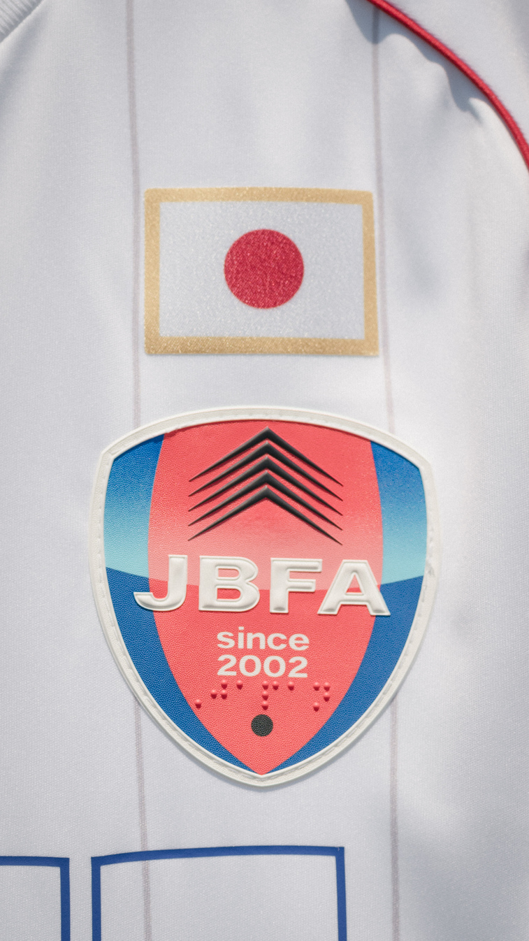 白ユニフォーム胸元のJBFAエンブレムと日の丸